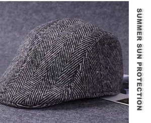 Close-up of black and white herringbone pattern on a thick wool driving cap for men