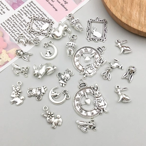Antique silver Alice in Wonderland themed rabbit pendants on vintage magazine background