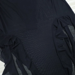 Close-up of black mesh fabric with ruffled edges and sheer texture details