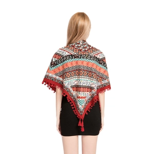 Detail view of Bohemian shawl with ethnic patterns and vibrant red fringe tassels