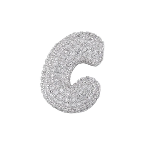 Macro shot of sparkling silver letter C pendant with pavé cubic zirconia inlay