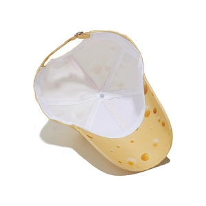 Internal view of a yellow cheese pattern sun hat showing the white lining and adjustable strap