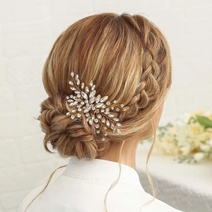 Close-up of a golden bridal hair comb with crystals worn on a low braided bun hairstyle