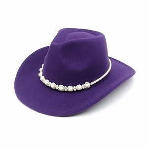 Detail of purple felt cowboy hat featuring floral pearl embellishments and curved brim