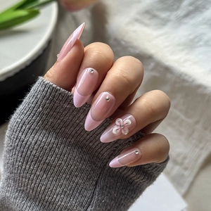 Detail von rosa French Almond Nails mit 3D-Blume und funkelnden Strasssteinen