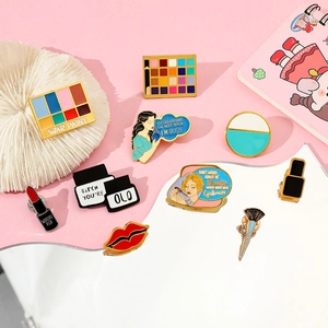 Flat lay of colorful enamel pins featuring makeup themes and retro female motifs