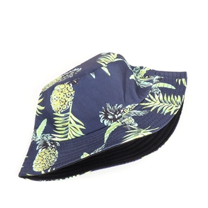 Detail of blue cotton bucket hat featuring tropical pineapple and leaf prints on wide brim