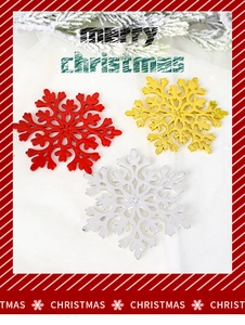 Close-up of red, gold and silver glitter snowflake ornaments on winter pine branches
