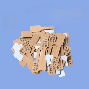 Macro detail of dumbbell-shaped kraft paper jewelry price tags on a blue background