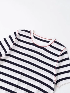 Close-up of knit fabric texture with black white stripes and red contrast stitching