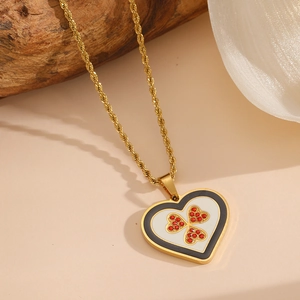 Détail du pendentif en cœur avec cristaux rouges et chaîne dorée torsadée