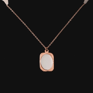 Detail van een roségouden roestvrijstalen vierkante hanger met getextureerde rand en glad midden