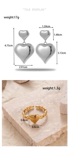 Detail view of silver double heart earrings and gold chain link heart ring on stone