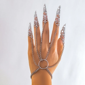 Bracciale gotico con artigli in argento e anelli punk su una mano da modella