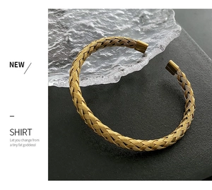 Detail shot of golden woven texture on a minimalist stainless steel cuff bracelet