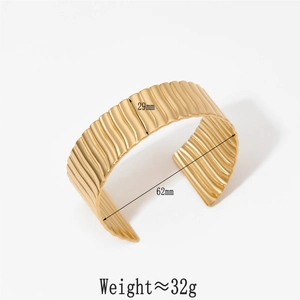 Detail view of gold textured wave wide open bangle with 29mm width and 62mm diameter size