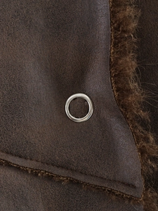 Detail of brown faux shearling jacket showing leather texture and silver metal eyelet