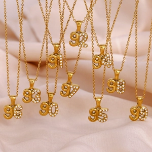 Detail of 18K gold plated number pendants with micro-paved zircons on pink silk