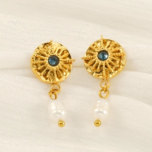 Star disk earrings with blue center stone and white pearl on white silk fabric