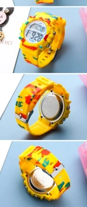 Detail view of yellow camo digital watch showing dial face and stainless steel back case