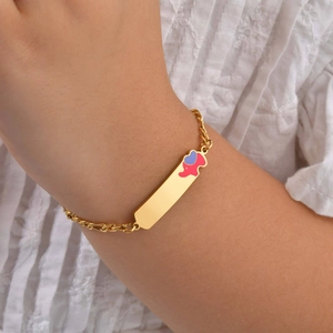 Golden stainless steel Figaro chain bracelet with pink elephant charm on model wrist