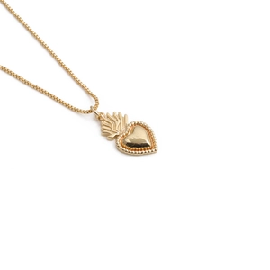Detailed view of a gold heart pendant with a fine box chain over a clean white background