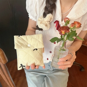 Detail of beige quilted bow pouch with snap button closure and Bozakka side label