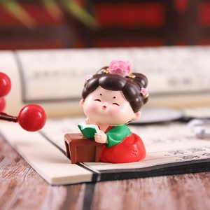 Detailed view of Tang Dynasty style girl figurine reading at a desk in Hanfu attire