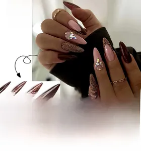 Detail of long stiletto press-on nails featuring brown French tips and crystal accents