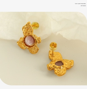 Detail of pink gemstone earrings with gold irregular textured metal borders