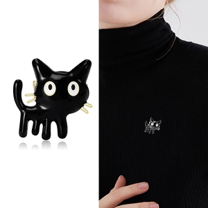 Cute black enamel cartoon cat brooch with gold whiskers shown on a model