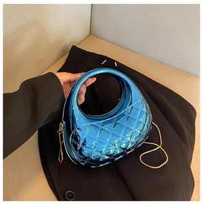 Close-up of bright blue metallic quilted cloud bag with gold chain and integrated handle