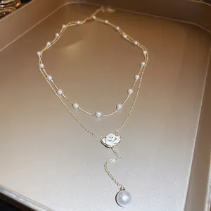 Double-layered golden necklace featuring elegant camellia flower and faux pearl accents