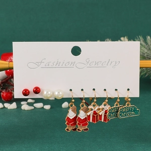 Detail view of five pairs of festive Christmas earrings including Santa and gift box charms