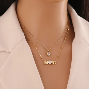 Double-layered gold heart necklace featuring a MOM pendant with clear sparkling stones