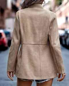 Detailed back view of a tan herringbone texture mid-length blazer with a tailored waist