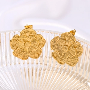 Elegant gold flower stud earrings with layered petals on a textured metallic finish