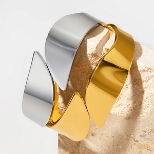 Polished stainless steel wide open bangles in gold and silver on stone display