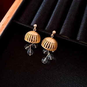 Macro shot of vintage gold tassel earrings with clear crystal beads on black velvet