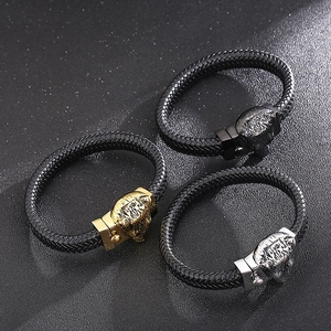 Detail of woven leather bracelets with lion head clasps in gold, silver, and black