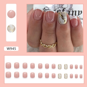 Short French style press-on nails in nude pink with white marble and gold foil accents