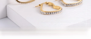 Macro shot of gold heart hoop earrings with sparkling pavé-set round cubic zirconia details
