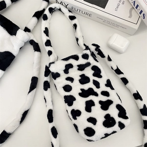 Detail view of plush cow print water bottle bag with soft furry strap and pattern