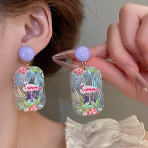 Artistic flamingo print acrylic drop earrings with purple studs and tropical floral patterns