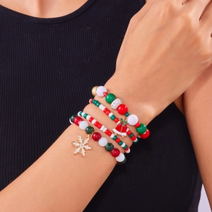 Dettaglio del bracciale natalizio multistrato con ciondoli a fiocco di neve e campanellini
