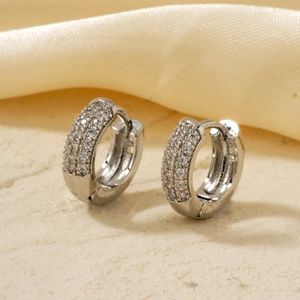 Silver hoop earrings with micro-paved white zircons on a soft silk and sand base