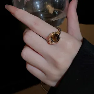 Vintage gold-plated ring with lava texture and round tiger eye stone on hand