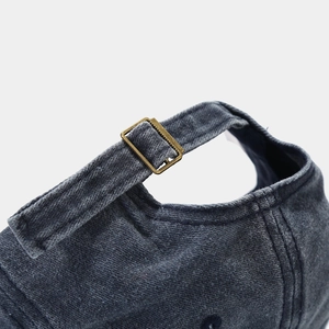Detail of adjustable metal buckle and washed denim texture on vintage baseball cap