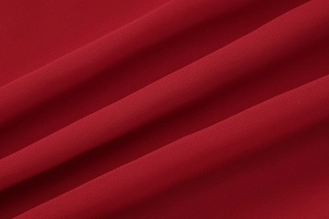 Vue macro détaillée du tissu en mousseline rouge foncé avec texture et drapé élégant