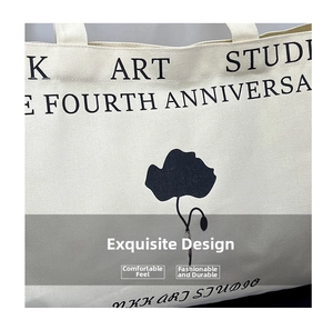 Detailed view of canvas tote bag featuring Art Studio print and floral graphic